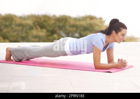 Working her core. Full length shot of a young woman doing yoga outdoors. Stock Photo