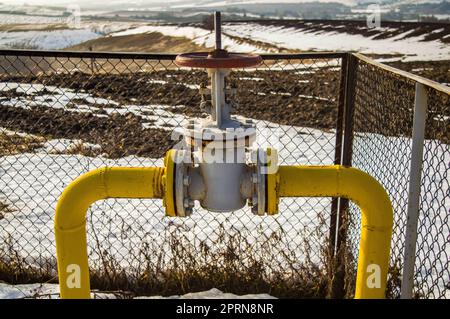 Gas pipe with valve for opening and closing the supply. Natural gas pipeline. Adjustment valve. North. White snow in winter. Flow. Industrial equipmen Stock Photo