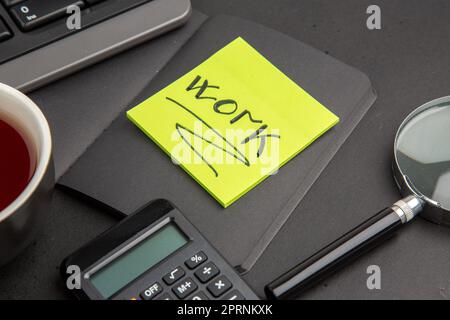 bottom close view black notepad cup of tea keyboard lupa calculator work written on note paper on dark background Stock Photo