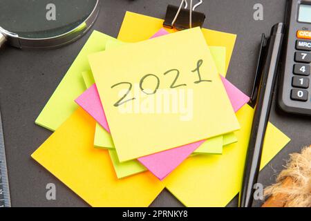 bottom close view written on sticky note colorful sticky notes lupa pen calculator on dark background Stock Photo