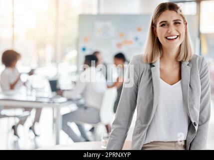 Portrait of a happy business manager and boss of a creative team of startup advertising designers. Proud, smiling businesswoman or leader feeling confident and happiness while working in the office Stock Photo