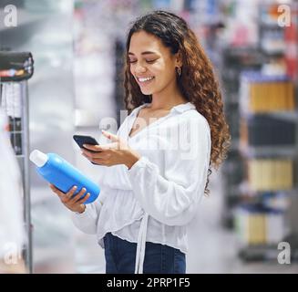 Woman shopping, phone and price check for inflation increase or discount coupon code. Young girl consumer calculating grocery tax of supermarket budget toiletries options on the shelf. Stock Photo