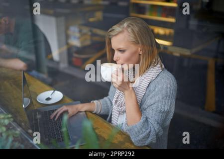 We all need somewhere to go to be alone. A young woman sitting in a coffee shop. Stock Photo