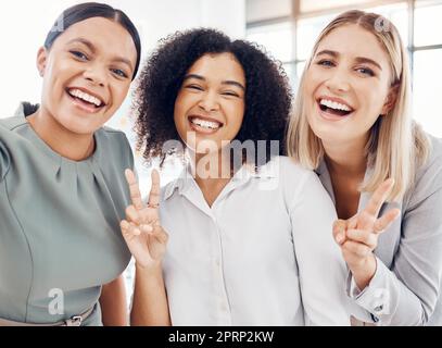 Selfie, team and portrait of business women happy, smile and silly during work break in office. Design, marketing and advertising diversity worker staff or girl friends together with peace emoji sign Stock Photo