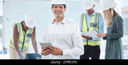 Architect, engineer and designer working on tablet, planning construction building job on mobile app and home renovation with workers at work. Portrait of happy manager and boss in architecture Stock Photo