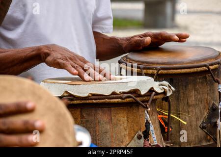 Percussionist playing a rudimentary atabaque in Salvador city Stock Photo