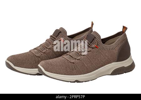 Closeup of a pair of modern brown sneakers or sports shoes isolated on a white background. Clipping path. Elegant and trendy mans shoes. Macro. Stock Photo
