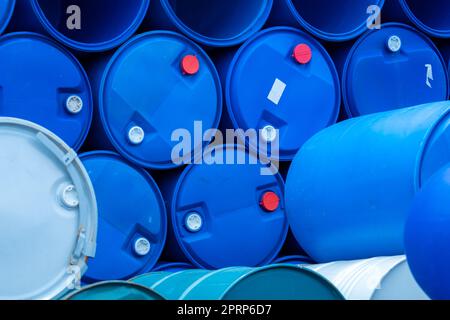 Old chemical barrels. Empty blue chemical drums stack. Steel and plastic oil tank. Toxic waste warehouse. Hazard chemical barrel. Industrial waste in drum. Hazard waste storage in factory. Stock Photo