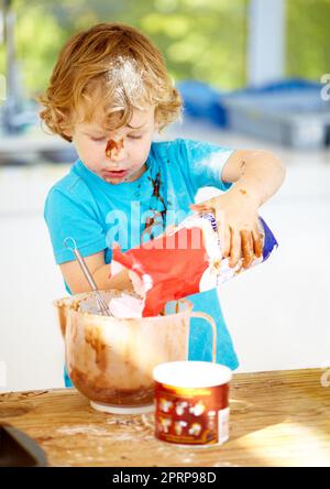 The future of the culinary arts. A little boy covered in dough and flour Stock Photo