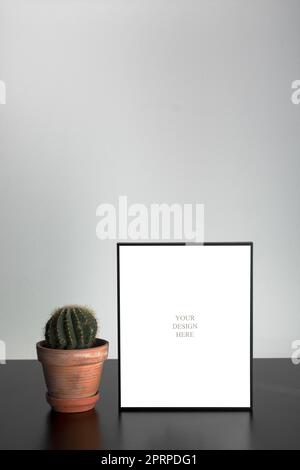 Mockup - Black photo frame on the black wooden table with succulent and white wall Stock Photo