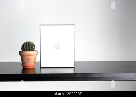 Mockup - Black photo frame on the black wooden table with succulent Stock Photo