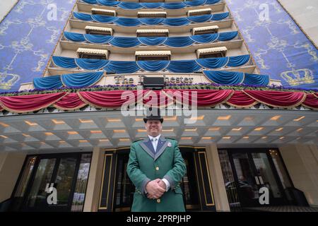 London UK. 27 April 2023. Doorman David poses in front of the Dorchester Hotel in Mayfair London which is  decorated to celebrate the coronation of King Charles III and Camilla Queen consort at Westminster Abbey on 06 May Credit: amer ghazzal/Alamy Live News Stock Photo