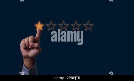 Businessman hand touches five stars rating feedback rating and positive customer review experience on virtual screen. Stock Photo