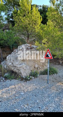 Attention sign for rock fall. Attention sign Falling rocks. Biokovo Mountain Nature park and trees from Makarska Riviera-Biokovo, Dalmatia, Croatia, Europe Stock Photo