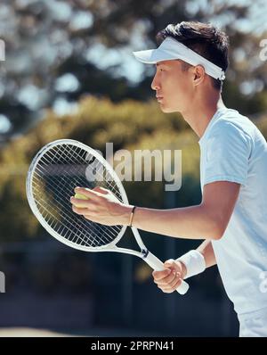 Tennis player, sports game and Asian man training for sport competition on court, motivation for fitness exercise and strong for game in nature. Japanese athlete ready playing in professional event Stock Photo