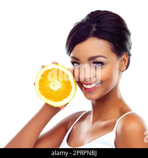 Good for my skin. A young woman in gymwear holding an orange and smiling at the camera. Stock Photo
