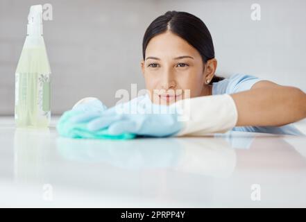 Cleaner woman cleaning kitchen counter with cloth, spray bottle and rubber  gloves in modern home in Stock Photo by YuriArcursPeopleimages