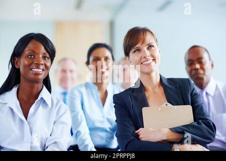 Colleagues listening to presentation. View of group of executives sitting and listening to presentation. Stock Photo