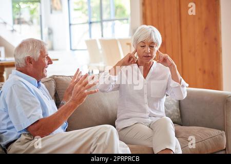 Im not listening anymore. a senior couple having an argument at home. Stock Photo