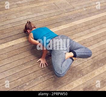 Perfecting the peacock pose. a young woman practicing yoga outdoors. Stock Photo