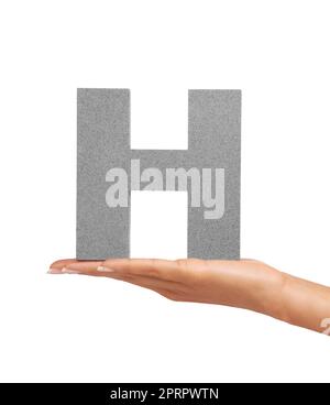 How do you do. A young woman holding a capital letter H isolated on a white background. Stock Photo