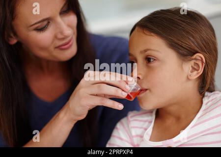 Mom knows best. a caring mother giving her sick little girl some medicine. Stock Photo