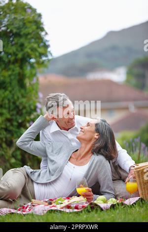 Falling in love all over again. a loving mature couple having a picnic on the grass. Stock Photo