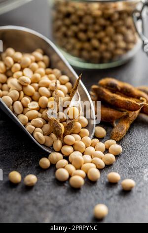 Soy beans. Dried soybean pod in scoop on black table. Stock Photo