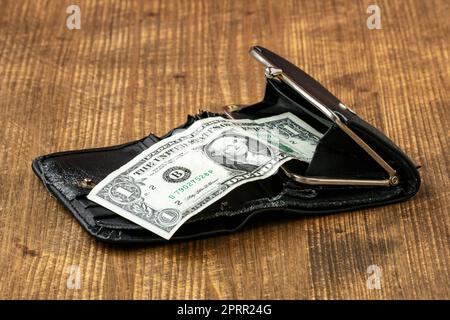 One American dollar in an old leather wallet on a wooden background Stock Photo