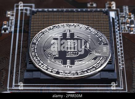 Cryptocurrency bitcoin silver coins on circuit board Stock Photo