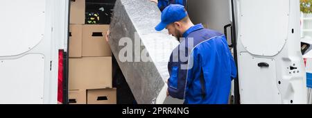 Furniture Mover Unloading Truck. Relocation Delivery Load Stock Photo