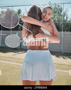 Women hug after friendly badminton game, court competition and congratulations friends win together. Social sports practice, celebrate healthy support Stock Photo