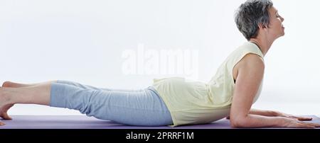 Stretch it out. Full length shot of an attractive woman stretching before yoga. Stock Photo