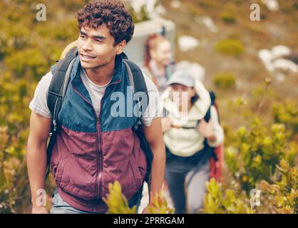 Hiking, friends and adventure with a group of young people wearing backpacks during travel, adventure and nature journey. Active, fitness and exercise with a happy man trekking to explore with mates Stock Photo