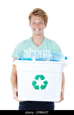 Lets reduce our waste. A happy young red-headed man holding a recycling bin filled with empty plastic bottles. Stock Photo