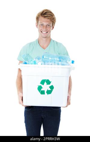 Recycling - its the right thing to do. A happy young red-headed man holding a recycling bin filled with empty plastic bottles. Stock Photo