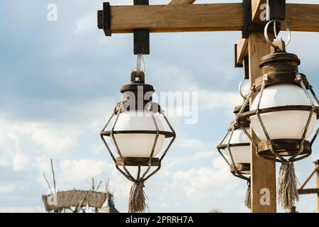 Old wooden lanterns hanging on a wooden pole. Stock Photo