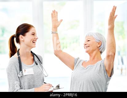 Your tests were negative. A doctor explaining positive test results to an overjoyed senior patient. Stock Photo