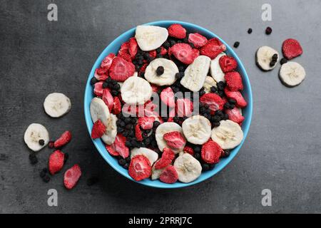 Bowl and dried fruits on grey table, top view Stock Photo