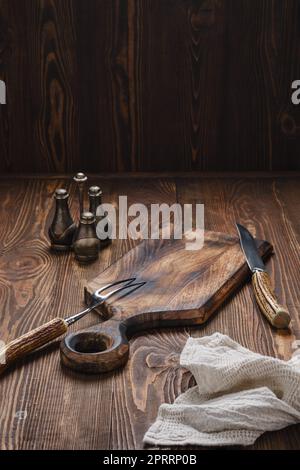 Empty wooden cutting board, fork and knife with for steak Stock Photo