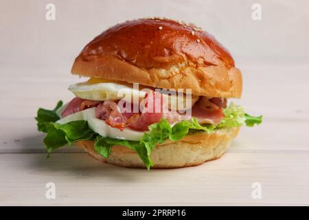 Soft focus photo of burger with mozzarella, bacon and fried egg. Stock Photo