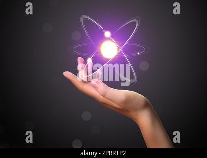 Woman and virtual model of atom on dark background, closeup Stock Photo