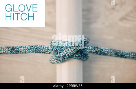 Above of hiking rope tied in a knot against a wooden background in studio. Glove hitch knot in a strong rope to secure safety while mountain climbing or extreme sports adventure. Stock Photo
