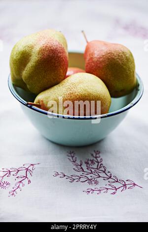 Ripe and ready to eat. a bowl of pears on a kitchen table. Stock Photo