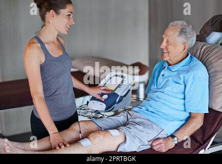 Youre coming along quite well. an elderly man having a physiotherapy session with a female therapist. Stock Photo