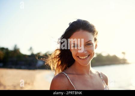 My happy place. Portrait of a beautiful young woman on the beach. Stock Photo