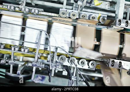 Racing through the production line. Detail shot of the workings of a printing factory. Stock Photo