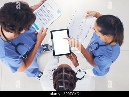 Doctors, nurse and team meeting with tablet, documents and paper working on planning, collaboration and data or analytics. Teamwork research people with tech for hospital management software or app Stock Photo