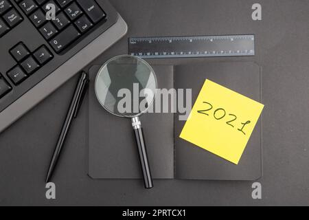 top view black notebook pen keyboard written on note paper lupa ruler on dark background Stock Photo