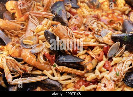 Italian Cavatelli allo scoglio, pasta with seafood and tomatoes close up in a frying pan Stock Photo